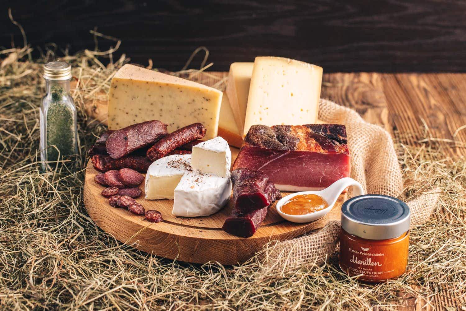 Tiroler Speck, Käse und Wildspezialitäten auf rustikalem Holzbrett